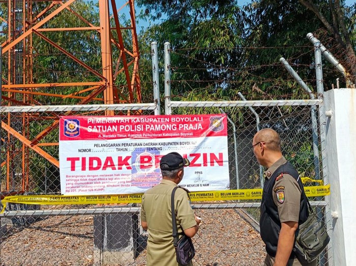 BTS (Base Transceiver Station) merupakan infrastruktur penting dalam jaringan telekomunikasi modern. Namun, tidak semua tower BTS yang didirikan memenuhi regulasi yang berlaku. Baru-baru ini, dua tower BTS ilegal di Boyolali menjadi sorotan setelah disegel oleh Satuan Polisi Pamong Praja (Satpol PP). Kejadian ini menimbulkan berbagai pertanyaan mengenai legalitas pembangunan tower BTS, dampaknya terhadap masyarakat, serta langkah-langkah yang diambil oleh pemerintah daerah. Dalam artikel ini, kita akan membahas lebih dalam mengenai peristiwa tersebut, mulai dari latar belakang pembangunan tower, proses penyegelan, hingga dampak sosial yang ditimbulkan. Latar Belakang Pembangunan Tower BTS Pembangunan tower BTS di Indonesia seringkali dilakukan untuk meningkatkan kualitas jaringan telekomunikasi, terutama di daerah-daerah yang belum terlayani dengan baik. Namun, dalam beberapa kasus, pembangunan ini dilakukan tanpa memperhatikan peraturan dan izin yang berlaku. Di Boyolali, dua tower BTS yang baru-baru ini disegel oleh Satpol PP terindikasi telah dibangun tanpa memenuhi syarat legalitas. Proses pembangunan tower BTS seharusnya mengikuti prosedur yang ketat. Pertama, perusahaan penyelenggara jaringan harus mengajukan izin lokasi yang sesuai dengan tata ruang wilayah setempat. Selain itu, mereka juga perlu mendapatkan izin dari pihak berwenang, termasuk dari Dinas Penataan Ruang, Dinas Perhubungan, dan Dinas Lingkungan Hidup. Jika salah satu izin tersebut tidak dipenuhi, maka pembangunan tower dapat dianggap ilegal. Di Boyolali, masyarakat setempat mengeluhkan kurangnya transparansi dalam proses izin pembangunan tower BTS. Banyak warga yang tidak merasa diberitahu atau dilibatkan dalam proses tersebut, sehingga keberadaan tower tersebut dianggap mengganggu. Masalah ini menjadi lebih rumit ketika ternyata tower-tower tersebut tidak memiliki dokumen resmi yang diperlukan. Hal ini menunjukkan adanya ketidakpatuhan dari pihak penyelenggara, yang berpotensi merugikan masyarakat. Proses Penyegelan oleh Satpol PP Penyegelan dua tower BTS ilegal di Boyolali dilakukan oleh Satpol PP sebagai bentuk penegakan hukum atas pelanggaran yang terjadi. Proses penyegelan ini tidak serta merta dilakukan, melainkan melalui serangkaian langkah yang mengikuti prosedur hukum yang berlaku. Satpol PP melakukan pemeriksaan terhadap dokumen-dokumen yang dimiliki oleh penyelenggara tower serta kelayakan lokasi yang dipilih untuk pembangunan. Sebelum melakukan penyegelan, Satpol PP juga melakukan sosialisasi kepada masyarakat mengenai keberadaan tower-tower tersebut. Masyarakat diberikan kesempatan untuk menyampaikan keluhan dan laporan mengenai aktivitas yang mereka anggap ilegal. Dalam hal ini, partisipasi masyarakat sangat penting untuk memberikan suara dan hak mereka dalam mengawasi pembangunan infrastruktur yang berdampak pada kehidupan sehari-hari. Setelah melalui proses verifikasi dan pengumpulan bukti, Satpol PP akhirnya memutuskan untuk menyegel tower BTS tersebut. Penyegelan ini dilakukan dengan memasang stiker resmi yang menyatakan bahwa tower tersebut tidak dapat beroperasi hingga adanya keputusan lebih lanjut. Selain itu, pihak Satpol PP juga memberikan peringatan kepada penyelenggara untuk melengkapi semua dokumen yang diperlukan dalam kurun waktu tertentu. Jika tidak, maka dapat dikenakan sanksi yang lebih berat. Dampak Terhadap Masyarakat Dampak dari penyegelan tower BTS ilegal di Boyolali tidak hanya dirasakan oleh penyelenggara, tetapi juga oleh masyarakat di sekitar lokasi. Di satu sisi, penyegelan ini dapat dianggap sebagai langkah positif dalam penegakan hukum dan perlindungan hak-hak masyarakat. Namun di sisi lain, penghentian operasi tower juga berpotensi mengganggu layanan telekomunikasi, terutama bagi warga yang sangat bergantung pada jaringan telekomunikasi untuk komunikasi sehari-hari. Masyarakat yang sebelumnya menikmati layanan dari tower BTS tersebut harus menghadapi kendala dalam berkomunikasi. Hal ini dapat berdampak pada berbagai aspek kehidupan, mulai dari komunikasi pribadi hingga kegiatan bisnis. Beberapa warga bahkan mengeluhkan bahwa tidak adanya layanan telekomunikasi yang baik akan menghambat akses mereka terhadap informasi penting, terutama di masa pandemi yang mengharuskan banyak kegiatan dilakukan secara daring. Selain itu, peristiwa ini juga menciptakan kesadaran di kalangan masyarakat mengenai pentingnya regulasi dalam pembangunan infrastruktur. Banyak warga yang mulai aktif mengawasi dan menuntut transparansi dari pihak-pihak terkait sebelum pembangunan infrastruktur dilakukan. Ini merupakan langkah positif yang menunjukkan bahwa masyarakat semakin peduli terhadap lingkungan dan kualitas hidup mereka. Tindakan Selanjutnya oleh Pemerintah Daerah Setelah penyegelan dua tower BTS ilegal di Boyolali, pemerintah daerah diharapkan mengambil langkah-langkah proaktif untuk mencegah kejadian serupa di masa mendatang. Salah satu tindakan yang perlu diambil adalah memperkuat regulasi dan persyaratan dalam proses pengajuan izin pembangunan tower BTS. Pemerintah perlu memastikan bahwa semua perusahaan penyelenggara jaringan mengikuti prosedur yang telah ditetapkan, demi menjaga kepentingan masyarakat dan lingkungan. Selain itu, sosialisasi kepada masyarakat mengenai pentingnya izin dan regulasi dalam pembangunan tower BTS juga perlu ditingkatkan. Masyarakat perlu diberikan pemahaman mengenai proses yang harus dilalui oleh penyelenggara sebelum mendirikan tower, serta hak-hak mereka sebagai warga negara untuk mengawasi pembangunan infrastruktur di lingkungan mereka. Pemerintah daerah juga dapat melakukan evaluasi terhadap tower-tower BTS yang sudah ada untuk memastikan bahwa semua tower tersebut memiliki izin yang sesuai. Jika ditemukan tower yang bermasalah, maka langkah penyegelan yang serupa dapat dilakukan untuk menjaga keabsahan dan legalitas infrastruktur telekomunikasi di wilayah tersebut.